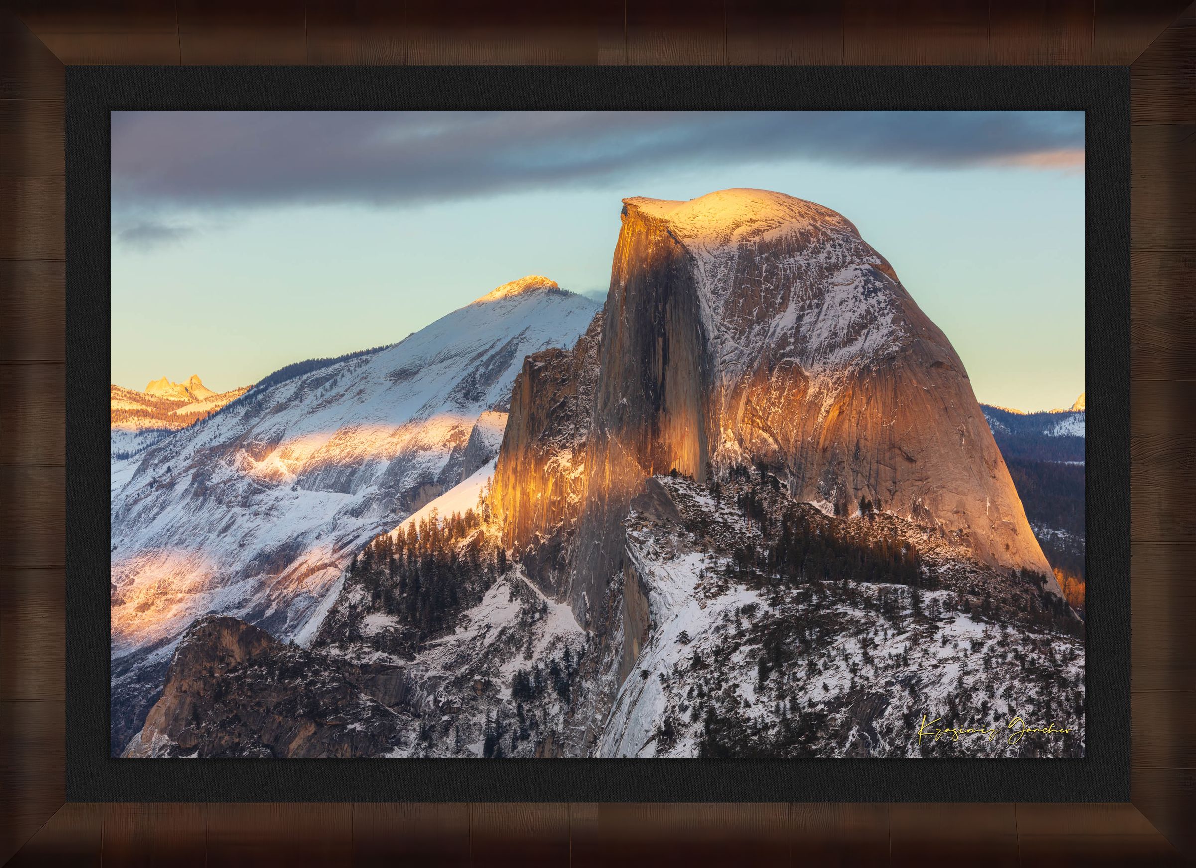 Half Dome monolith illuminated by golden sunset light amidst snow-covered peaks and clouds in Yosemite National Park. #Finish_Roma Cigar Leaf Frame & Dark Liner