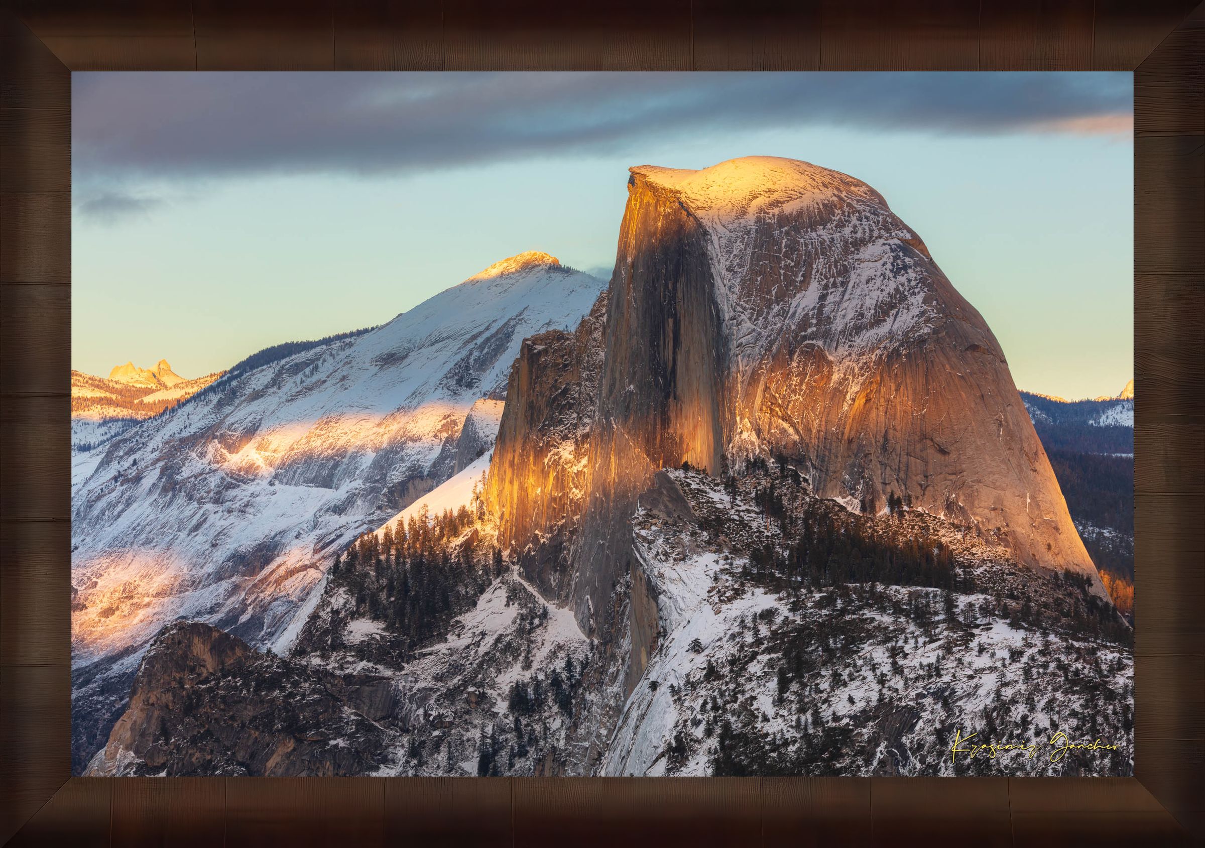 Half Dome monolith illuminated by golden sunset light amidst snow-covered peaks and clouds in Yosemite National Park. #Finish_Roma Cigar Leaf Frame