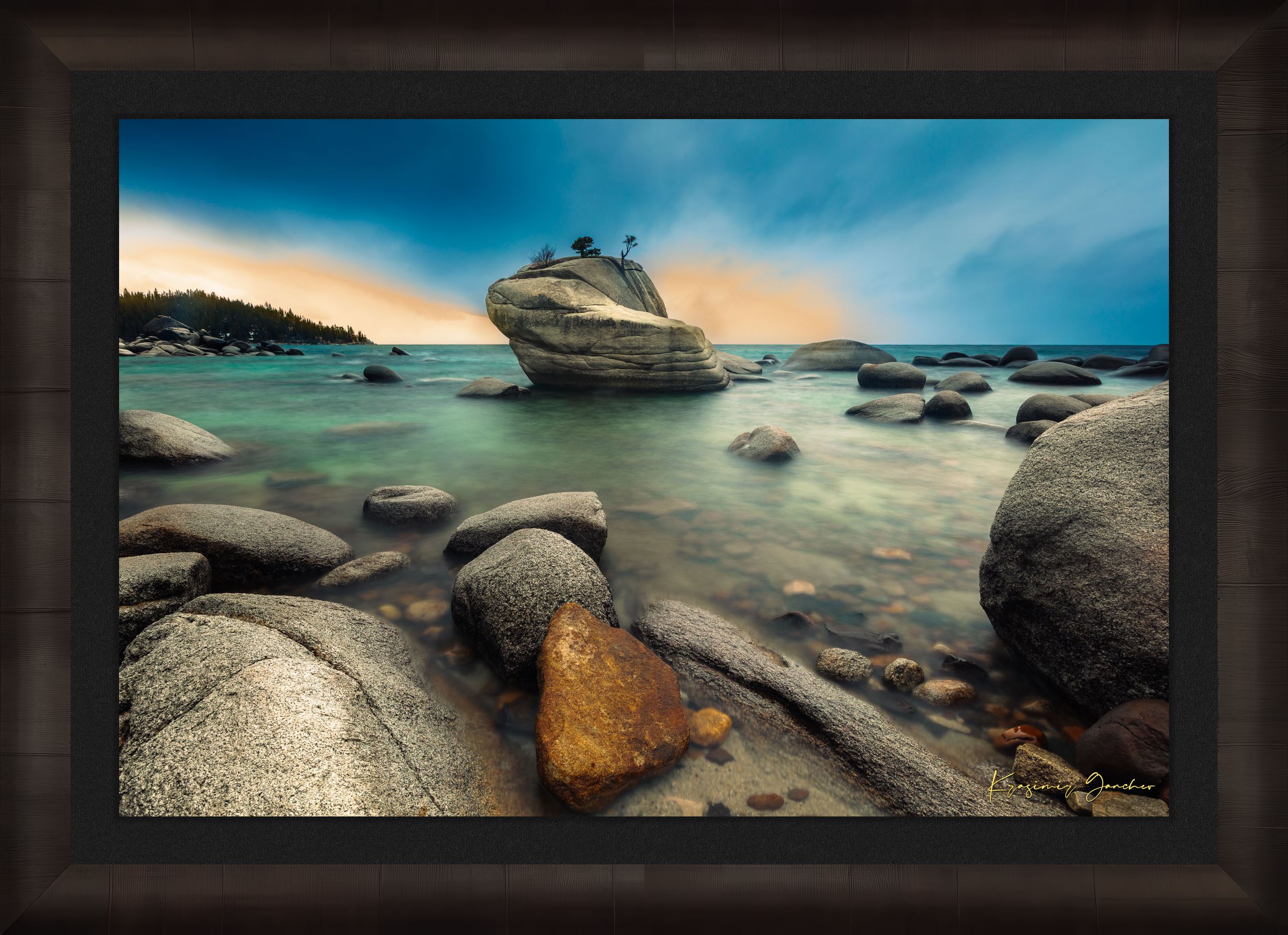 Bonsai Rock formation beside a calm lake in Lake Tahoe during sunset with gentle ripples and clouds. #Finish_Roma Dark Ash Frame & Dark Liner