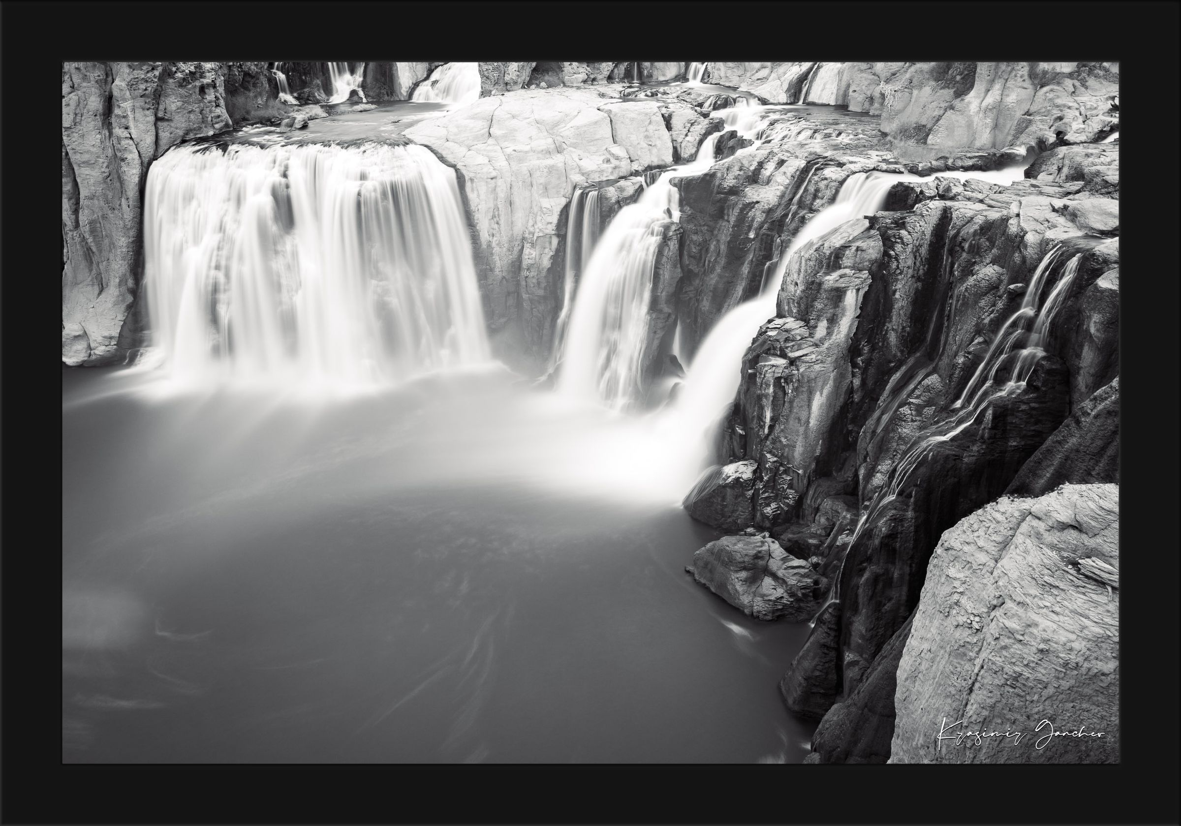 Black and white photograph of a powerful Shoshone Falls waterfall cascading into dark recesses with blurred water motion. #Finish_Roma Satin Black Frame