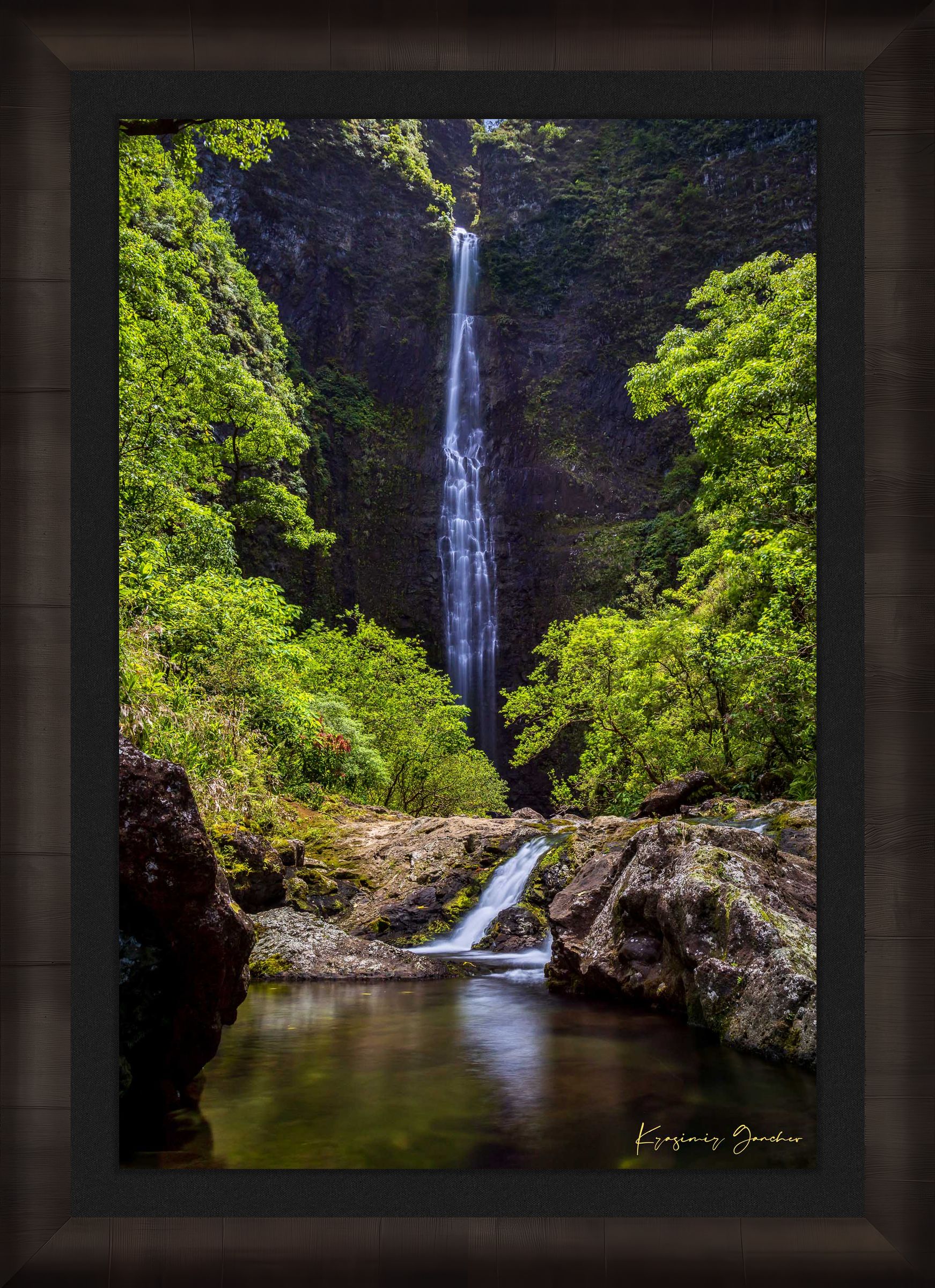 Small waterfall veiled in mist beneath dense foliage at Hanakapiai Falls, Kauai, lit by daylight. #Finish_Roma Dark Ash Frame & Dark Liner