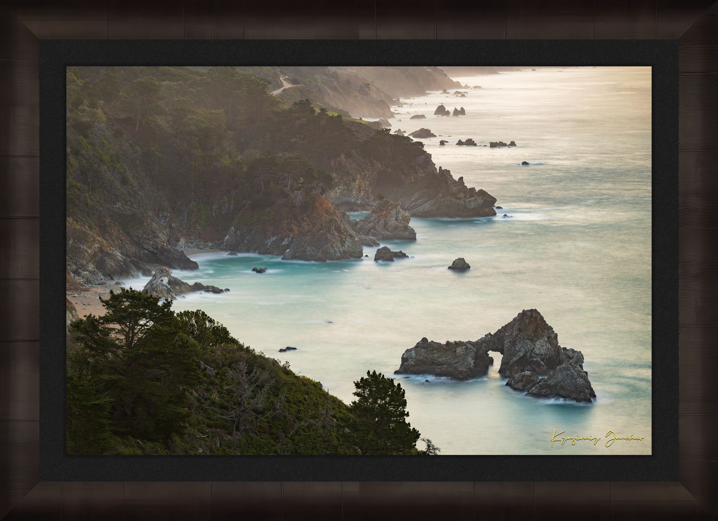 Coastal rock formation known as McWay Rocks at dawn on the Big Sur coastline with lush vegetation and ocean view. #Finish_Roma Dark Ash Frame & Dark Liner