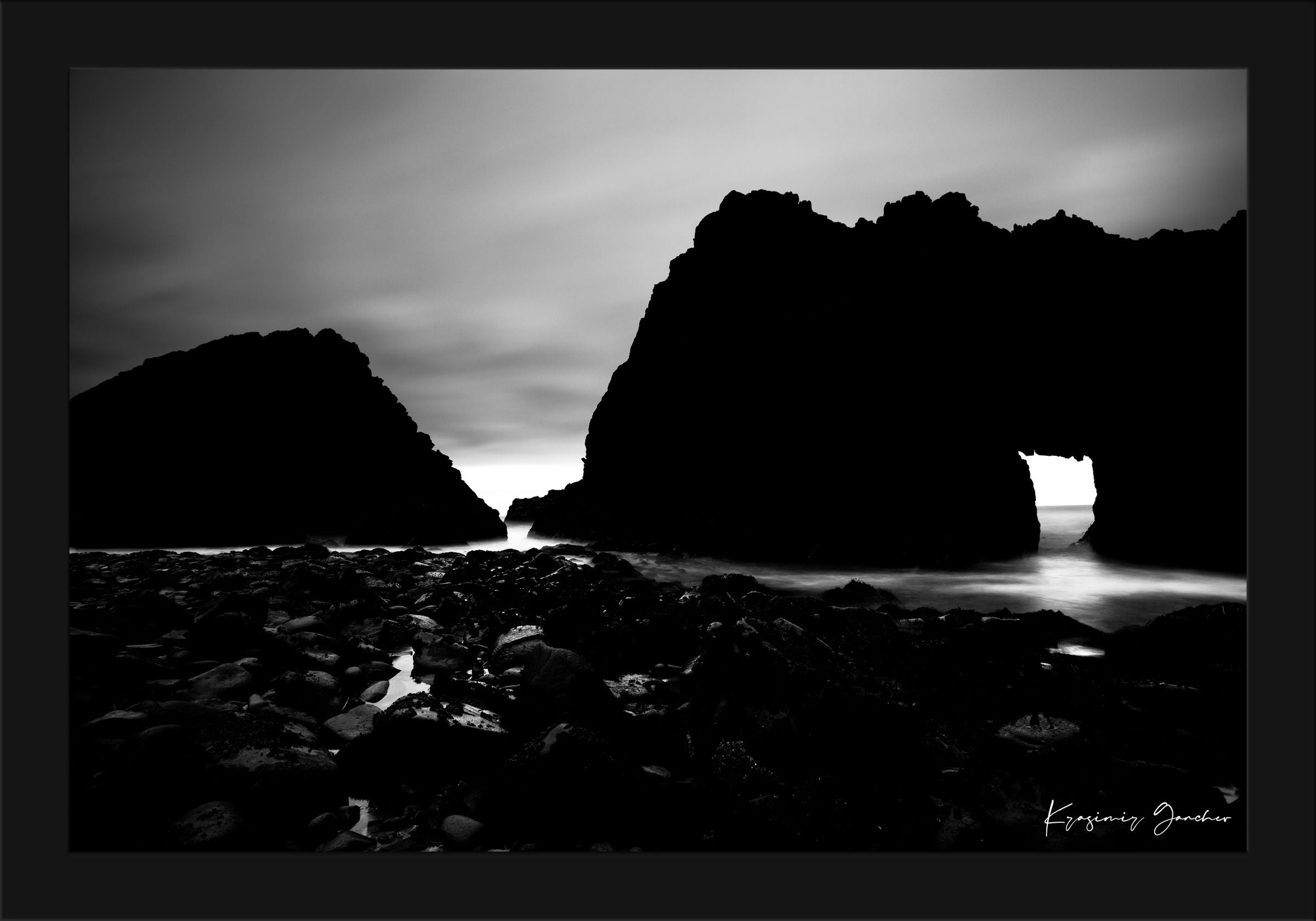 Silhouette of Keyhole Arch at Big Sur under dusky sky with cloud and wave detail. #Finish_Roma Satin Black Frame