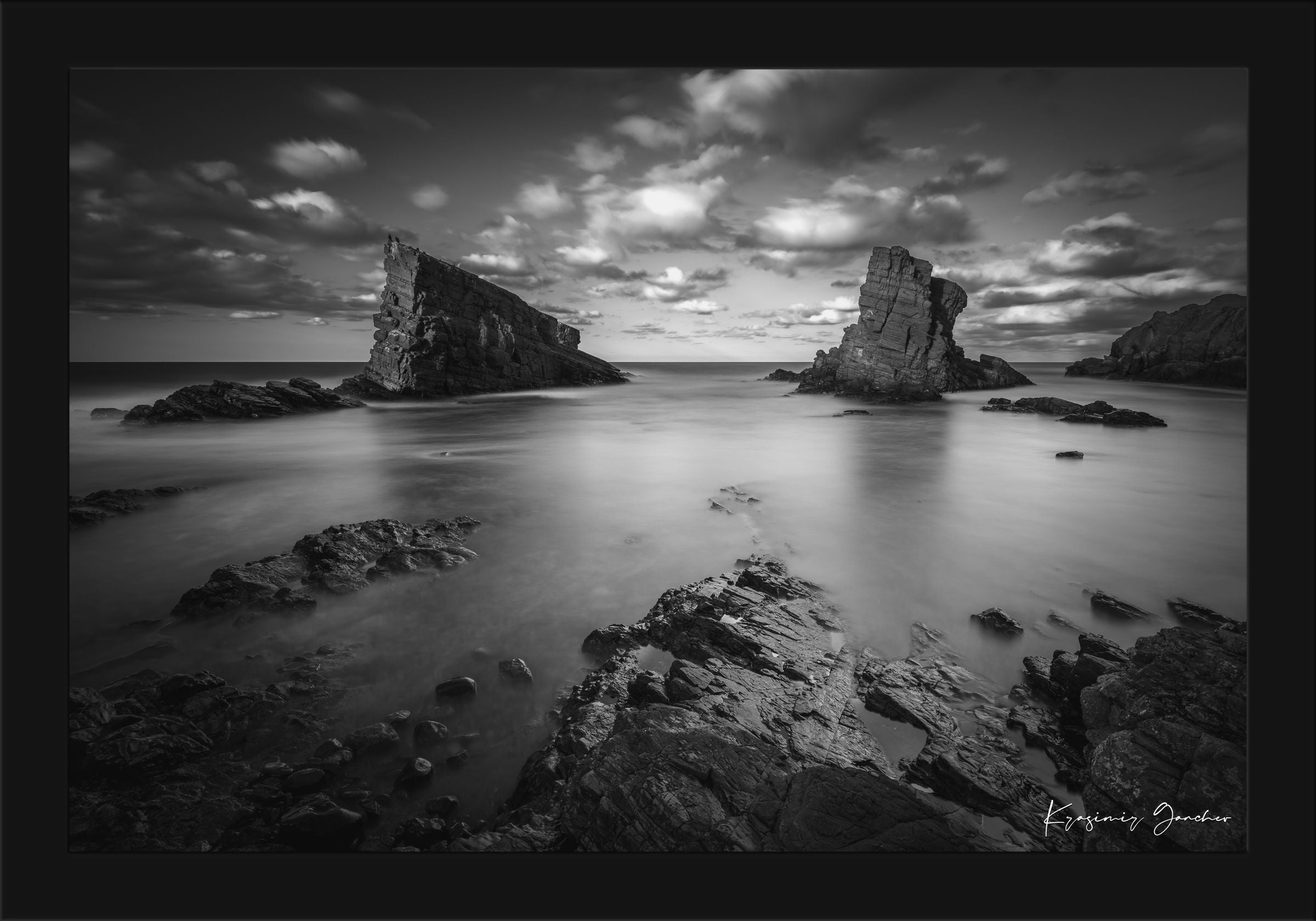 The Stone Ships rock formations at Sinemorets, Bulgaria, captured in black and white during a sunset with clouds over the sea. #Finish_Roma Satin Black Frame