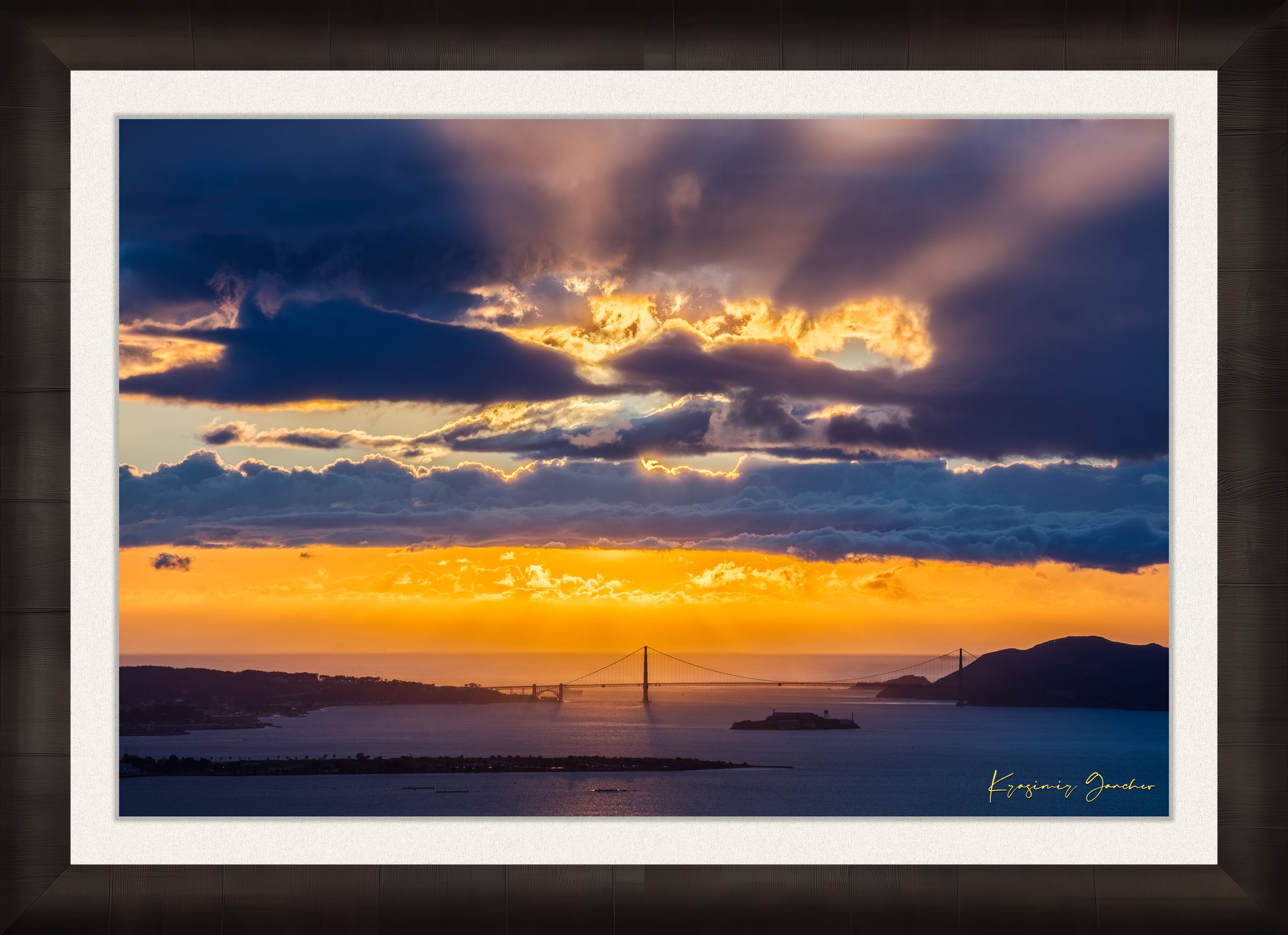 Golden Gate Bridge spanning a sunlit bay at sunset under layered stormy clouds, warm hues blending into cool sky tones. #Finish_Roma Dark Ash Frame & Bright Liner