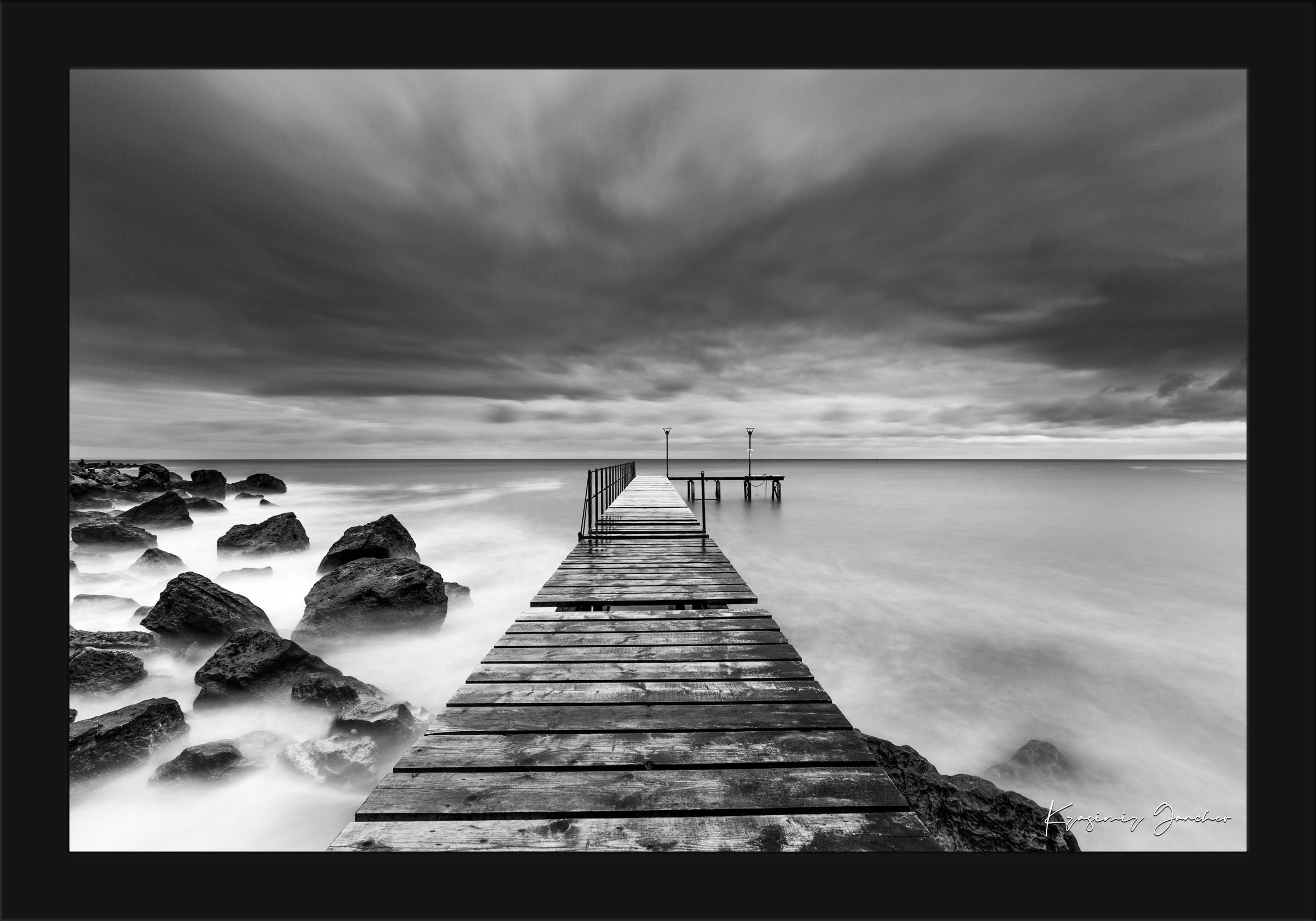 Coastal rocks and pier along the Black Sea coast during storm, wave activity visible. #Finish_Roma Satin Black Frame