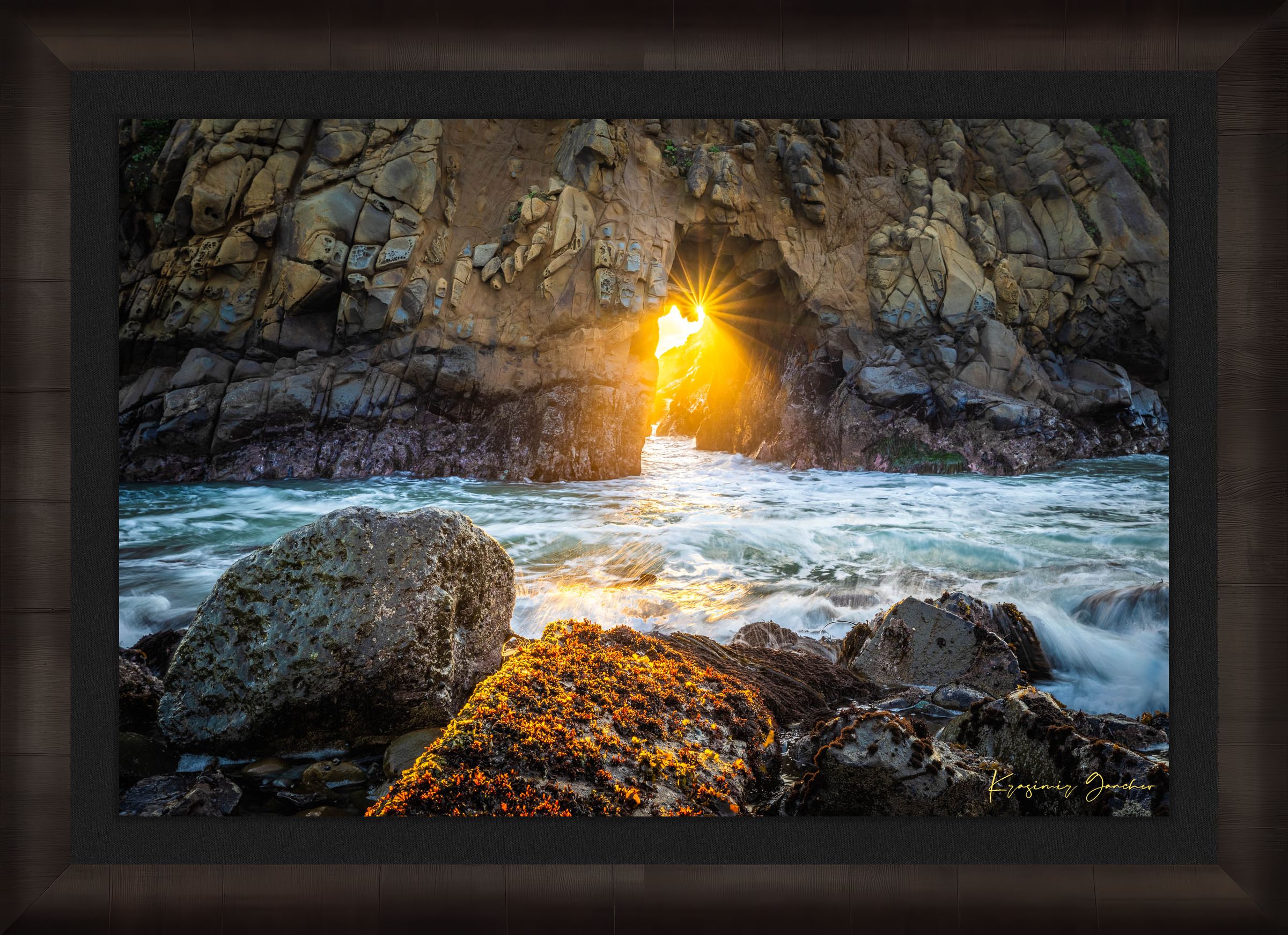 Golden-hour photograph of a coastal arch formed by erosion at Big Sur's rugged shoreline, featuring boulders and open sea. #Finish_Roma Dark Ash Frame & Dark Liner