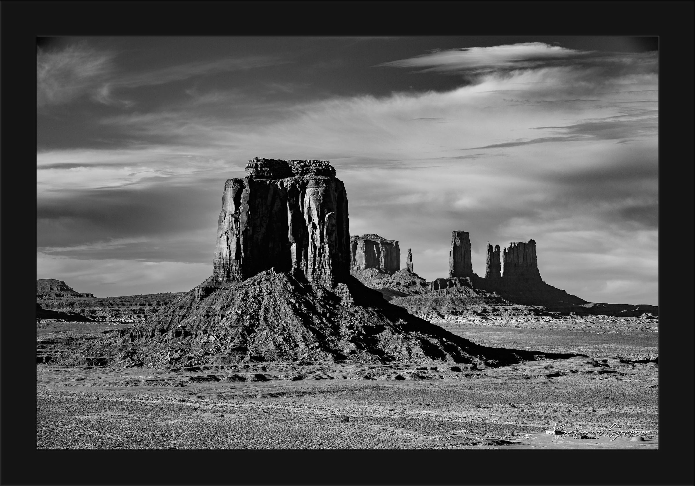 Timeless black and white landscape of Monument Valley's towering formations under dawn skies with soft cloud cover. #Finish_Roma Satin Black Frame