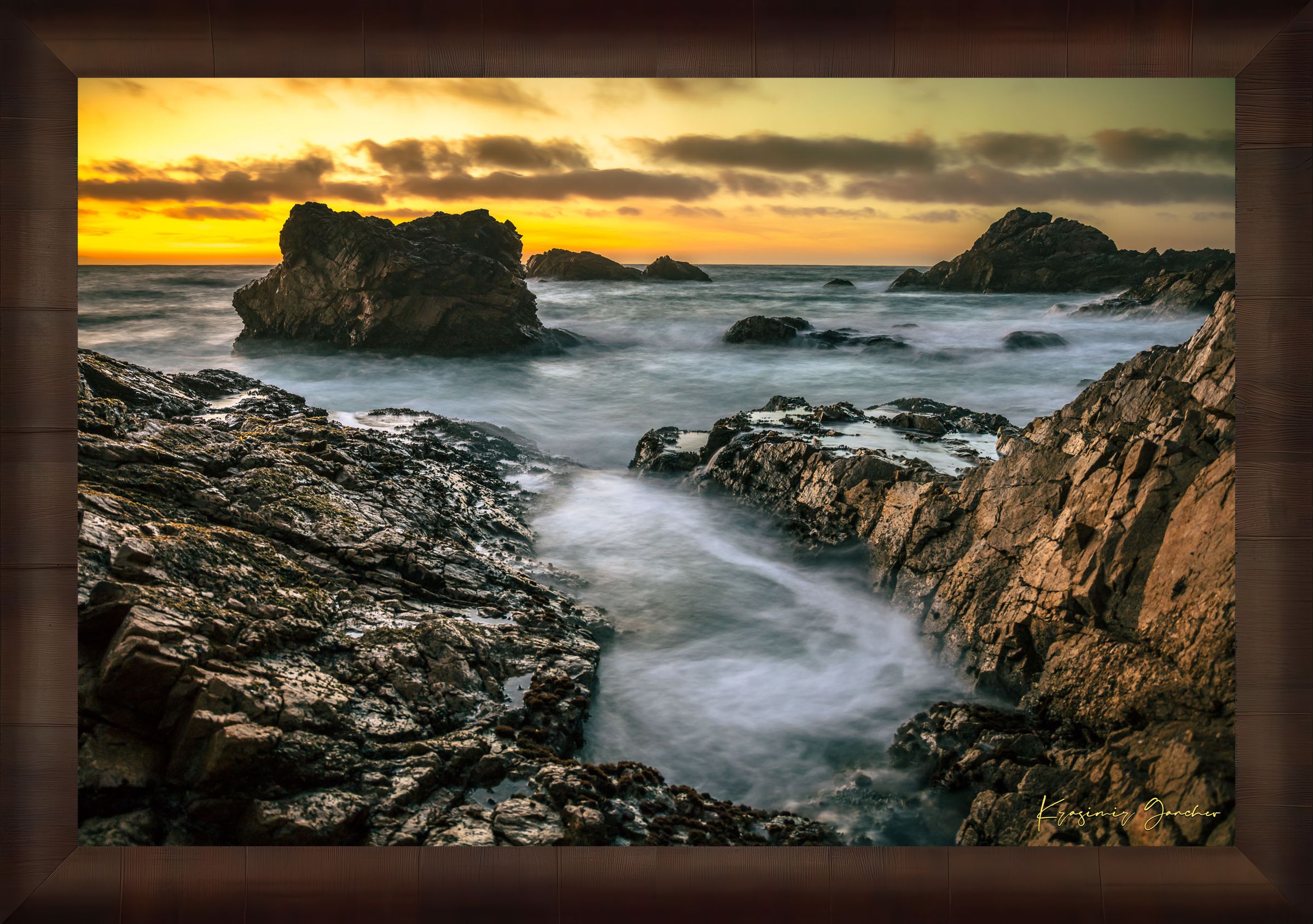 Jagged rocky cliffs along the Big Sur coast with rhythmic wave action, open ocean mist, clouds above, illuminated by late afternoon sunlight. #Finish_Roma Cigar Leaf Frame