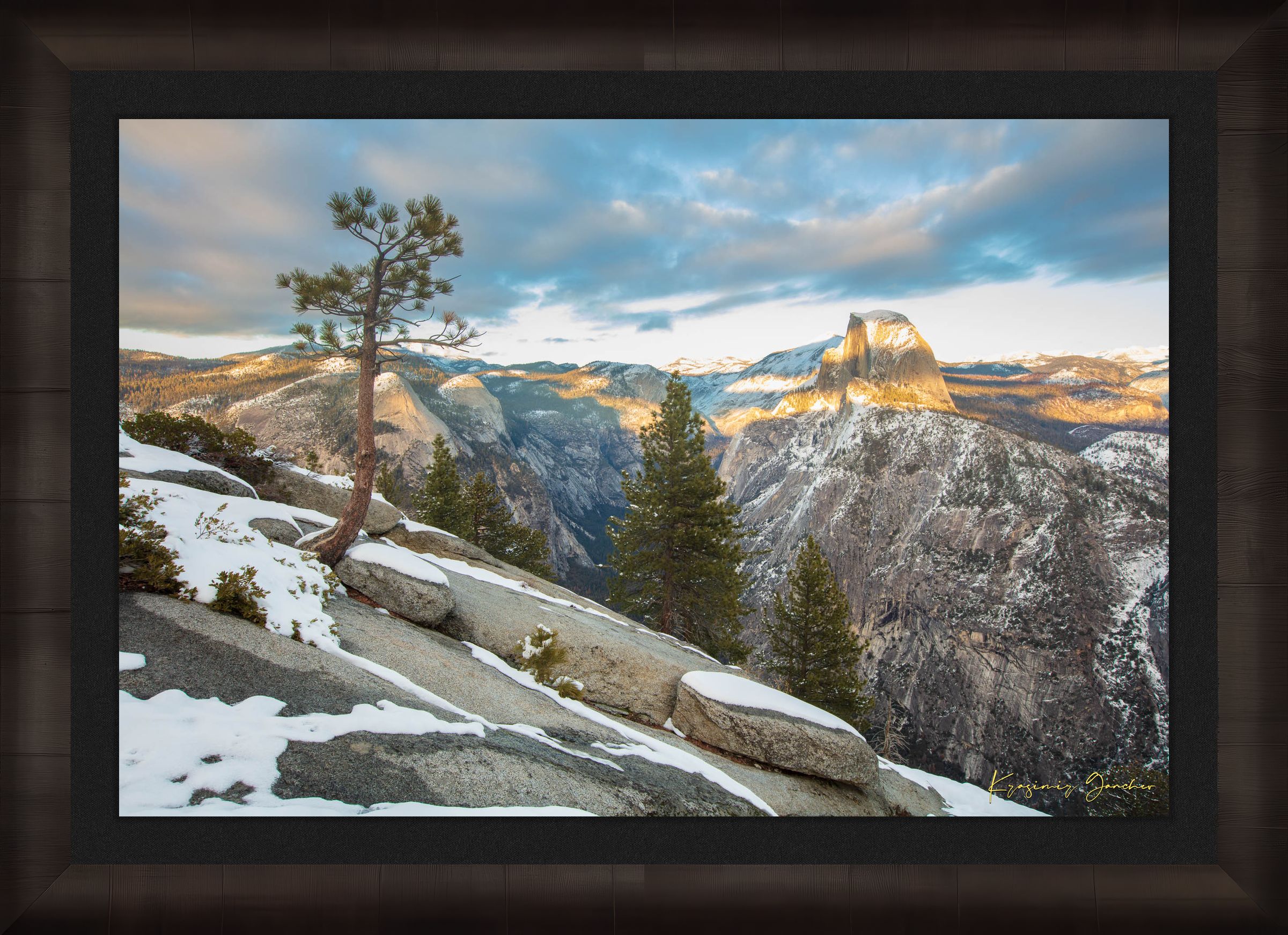 Majestic Half Dome in Yosemite National Park bathed in golden sunset light, covered in snow with wisps of cloud moving across the sky. #Finish_Roma Dark Ash Frame & Dark Liner